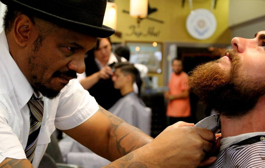male customer having his beard trimmed in a barber shop